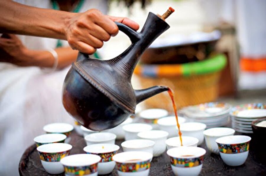 Buna + Etiyopya

                                    
                                    Tüm dünyada en ünlü zincir markaların kullandığı Etiyopya kahveleri, anavatanında öyle tüketiliyor ki, abartı mı yoksa keyif mi ayırt etmek zor. Türkiye'deki yoğun çay tüketimine oldukça benzeyen bunanın yapılışı da içimi de bir ritüel. İbikli büyük bir kapta hazırlanıp kömür ateşinde bolca pişirilen buna, küçük fincanlar ile servis ediliyor ve genelde bir fincan yeterli olmuyor. 
                                
                                