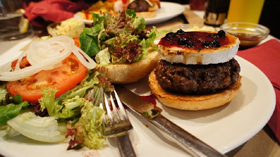                            Peki, kocaman leziz ve sulu görünüşü iştah kabartan bir hamburgere kim hayır diyebilir ki? 

                                    Hazır satılan hamburger ekmeği, cheddar peyniri, marul, soğan, turşu, domates, hardal sosu, ketçap ve mayonez kullanarak yapılan bu hamburger de önemli olan köftenin tadı ve pişme süresi. 

Yarım kilo kıymaya bir yumurta, bir tutam kimyon, karabiber, tuz ve yenibahar ilave edin. Güzelce yoğurduktan emin olduktan sonra şekil verin elinizle. Ancak istediğiniz büyüklükten daha büyük şekillendiren ki tavada pişerken küçülen köfteler hamburger ekmeğinde komik durmasın. Sonra diğer malzemeleri içine yerleştirip besleyici ev burgeri yapabilirsiniz.
                                