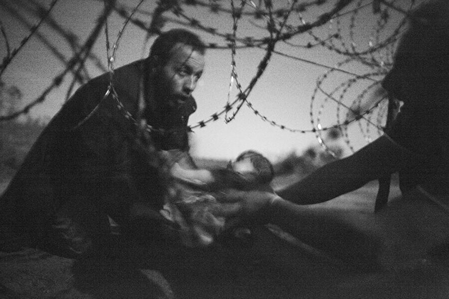 2016
Avusturyalı fotoğrafçı Warren Richardson'ın çektiği Sırbistan- Macaristan sınırında tel örgüleri aşmaya çalışan mülteciler fotoğrafı 2016'nın en iyisi seçildi. 

Kaynak: World Press Photo
