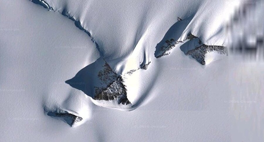 Gizli yapılar
Antarktika'nın buz kaplı yüzeyinin altında gömülü 22 km uzunluğunda bir yapı 2012 yılında Google Earth kullanılarak fark edilmişti. Bazı araştırmacılar bunun buz altında gizlenmiş dev bir istasyon olduğunu, diğerleri ise UFO olduğu tezini savunuyor. Yükseltiyi kaplayan kar yığını üzerindeki fırça darbelerine benzeyen izler birilerinin bir şeyler gizlemeye çalıştığı izlenimini veriyor.