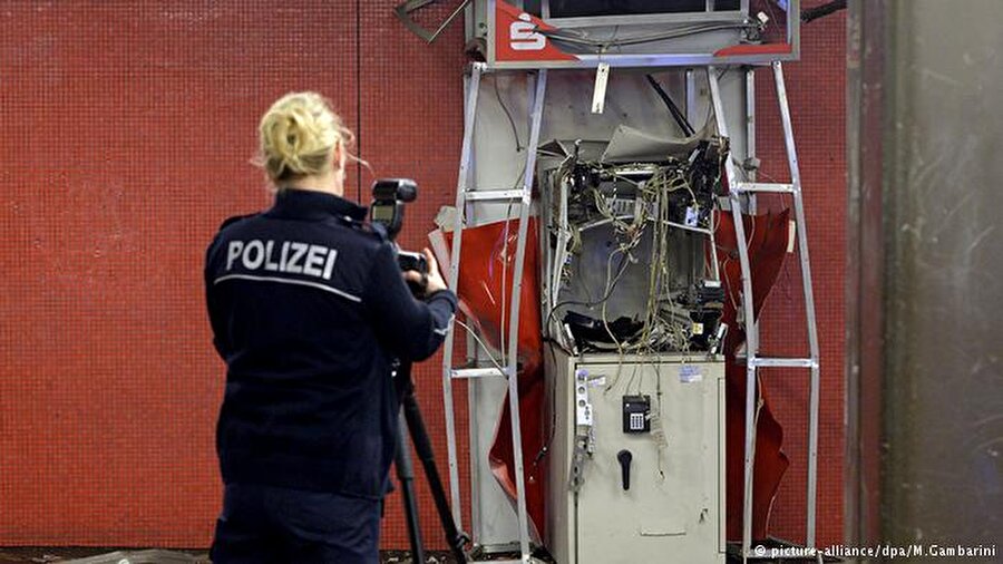 Hırsızlığa karşı paralara boya dökülüyor

                                    Berlin'deki bu ATM, Ağustos 2016'da kanunsuzların kurbanı oldu. Pek çok makinede, herhangi bir tahribat durumunda otomatik olarak devreye geren ve paraları geçersiz hale getiren bir boya püskürtme sistemi bulunuyor. Ancak bu önlemin artık devre dışı kaldığı bilgisi, soyguncular arasında hızla yayıldı ve arka arkya Almanya başkentindeki bankamatikler hedef alındı.
                                