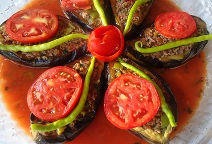 Karnıyarık
Patlıcanları çizgili soyup, tuzlu suda bekletin. Yıkadıktan sonra suyunu havlu ile çektirin ve az yağda kızartın. İsterseniz patlıcanları fırına da atabilirsiniz. Patlıcanları tepsiye dizin ve üzerine yağ gezdirip fırından pişirin. Karnıyarık bu şekilde daha hafif olacaktır. Ayrı bir tencerede iç harcı hazırlayın. Soğanları kavurun ve kıymayı ekleyin. Rendelenmiş domates, maydanozu, tuzu ve baharatları ekleyerek iç harcı karıştırın. Pişirdiğiniz patlıcanların içine iç harcı doldurun ve üzerini domates ve biberle süsleyin. Ayrı bir yerde salçayı sıcak suda ezerek patlıcanların aralarına dökün. Daha sonra 170 derece de önceden ısıtılmış fırında pişirin.