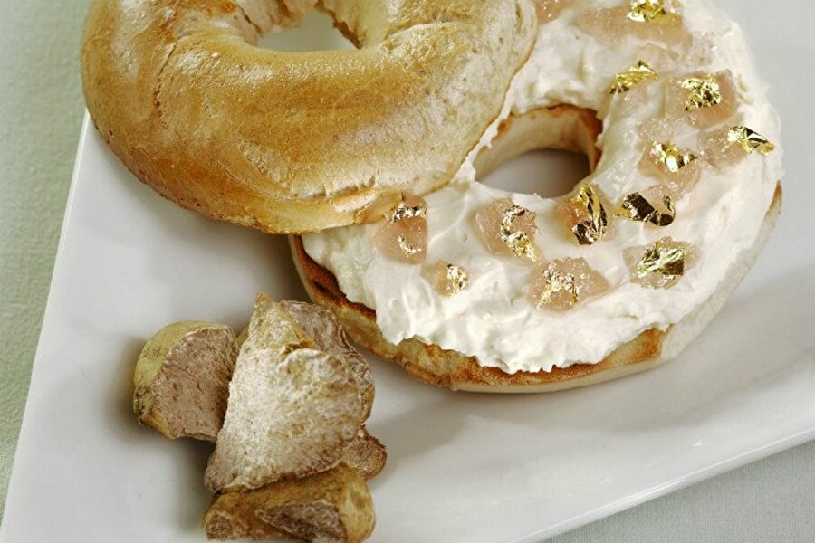 Bagel – 1000 Dolar
Aslında bizim yediğimiz açmadan pek farklı olmayan bir ekmek türüdür bagel. Fakat buradaki sunumda farklı olan bagelin içerisine konan meyvede. Goji berry ile hazırlanan bagel ister istemez biraz pahalı oluyor fakat asıl pahalı yapan nokta ise bagelin yanındaki altın yapraklar. Evet, yenilebilir altın yapraklar ile sunum yapılıyor olması bunun fiyatını 1000 dolara kadar yükseltiyor. 