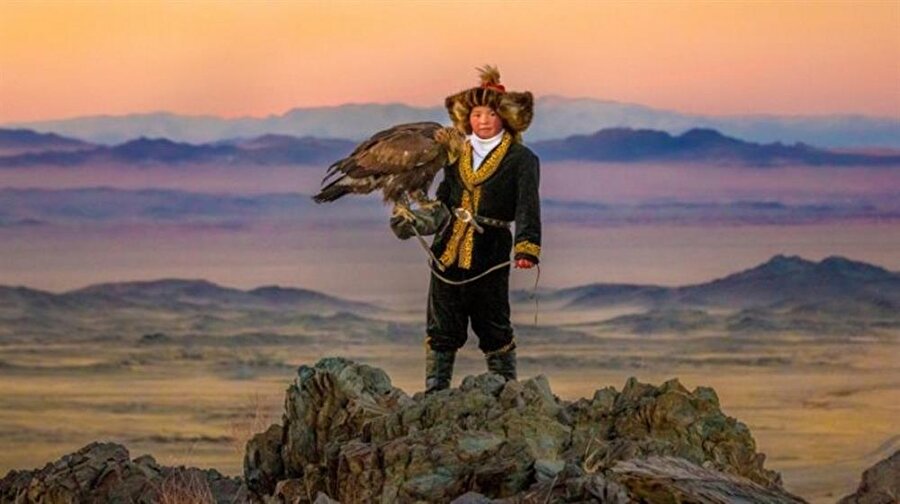 Kartal Avcısı Kız – The Eagle Huntress 
Vizyon Tarihi: 14 Nisan 2017

 Dev pençeleri ve jilet gibi keskin gagaları ile vahşi kartalları eğitmek size imkânsız gözükse de Kazaklar bunu yüzyıllardır yapıyor. Moğolistan'ın Bayon-Ölgii bölgesinde ise bu geleneğe en sadık kalan Kazaklar yaşamaktadır. 13 yaşında, göçebe bir ailenin çalışkan kızı Ayçolpan da bu geleneğe gönül vermiş Kazaklardan biri. Fakat onun özelliği 12 nesil boyunca babadan oğla geçmiş bu geleneğin ilk kadın mirasçısı olmaktır. Dağların tehlikeli yamaçlarında anne kartallar tehditkâr şekilde uçarken Ayçolpan bu idealini gerçekleştirmek üzere yapması gereken şeyi cesur ve kararlı şekilde yapar ve kendi yavru kartalını yakalamayı başarır. Bu, kartalını eğitmek için babası ile girişeceği zorlu ve uzun eğitim sürecinin henüz ilk adımıdır. 

Nefes kesici atmosferi ve çok özel gerçek görüntüleri ile bu belgesel film Ayçolpan'ın kişisel yolculuğuna ışık tutarken evrensel bir sinema dili yakalamayı başarıyor.