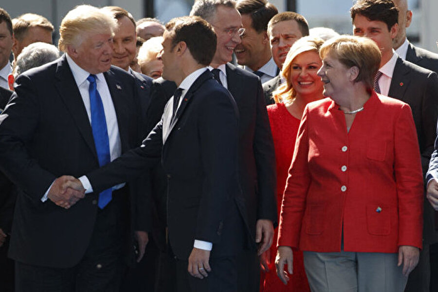 
                                    
                                    ABD Başkanı Trump, Fransa'nın çiçeği burnunda Cumhurbaşkanı Emanuel Macron'la selamlaşırken meşhur el sıkışma hareketini yaptı.
                                
                                