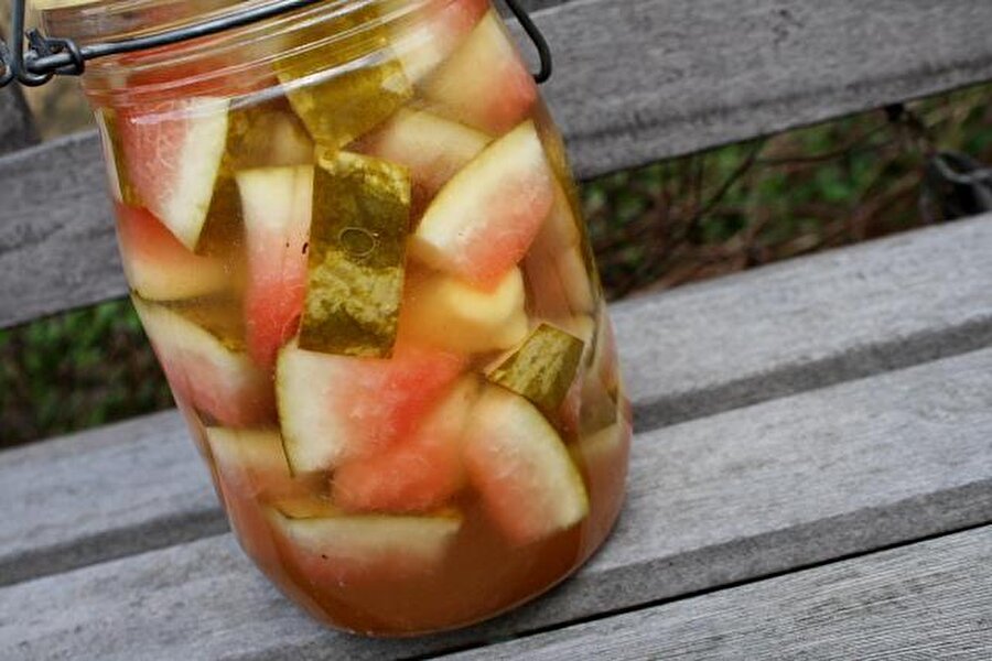 Karpuz kabuğu turşusu
Bu leziz öneri hem Türkiye’de hem de Avrupa’nın birçok yerinde yapılıyor. “Karpuzdan turşu mu olur?” diyenlerin ağızlarını açık bırakacak bu lezzeti evlerinizde kolaylıkla yapabilirsiniz.
Malzemeler:Karpuz kabuğuKaya tuzu
MaydanozFermente edilmiş sirkeSu
Yapılışı:
Öncelikle karpuz kabuklarında kırmızı kısımları kalmayacak şekilde temizleyin. Kabuğun yeşil sert kısmı da soyulur. Soyulan kabuklar güzelce yıkanır. Kabukları süzülmeleri ve kurumaları için bir süre dinlendirin. Dilediğiniz büyüklükte kestiğiniz kabukları, kavanozlara yerleştirin. Kabukların üzerlerine maydanozları dizin. 1 kilo kabuk için; 1 çay bardağı sirke, iki yemek kaşığı kaya tuzu ve 1 litre suyu karıştırın. Hazırladığınız suyu kabuklara paylaştırın. Yaklaşık bir ay sonra turşunuzu tüketebilirsiniz.