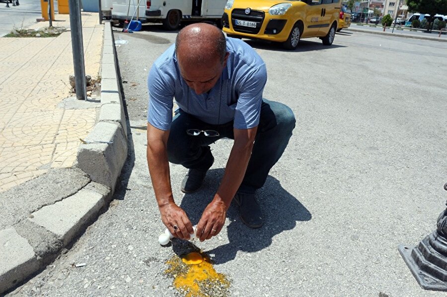 Asfaltta yumurta pişirdi, ekmek banıp yedi