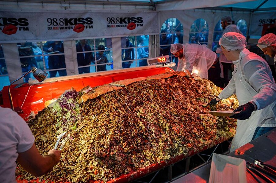 423 kilo döner dağıtarak dünya rekoru kırdılar
Almanya'nın Berlin şehrinde rekorlar kitabına giren bir olay yaşandı. Daha önce 413 kilo dönerle kırılan rekor, Berlin kentinde yayın yapan radyo istasyonun hazırladığı 423.5 kiloluk dönerle rekoru güncelleyerek, rekorun yeni sahibi oldu.