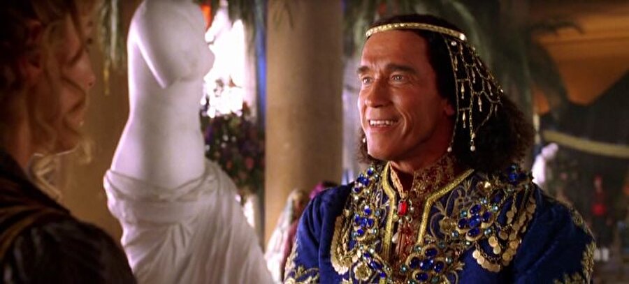 Arnold Schwarzenegger (Around the World in 80 Days)
Jules Verne’in ünlü eseri “80 Günde Devr-i Alem”in 2004 tarihli Disney yapımı uyarlamasında, Jean Passepartout rolünde Jackie Chan, ünlü gezgin Phileas Fogg rolünde de Steve Coogan vardı. Film Walt Disney Pictures’ın büyük zarar eden işlerinden biriydi, gelen eleştiriler de hiç parlak değildi. Bizi ilgilendiren kısmı ise, Avusturya aygırı Arnold Schwarzenegger‘i “Hapi” isminde bir Türk prensi olarak görmemiz. Filmde Hapi ud çalıyor, tuhaf danslar ediyor ve Arnie’nin üstüne yapışmış Alman aksanıyla konuşuyor. Schwarzenegger’i Türk rolünde oynatmak kimin fikriydi bilmiyoruz, ancak enteresan sonuçlar doğurduğu kesin.