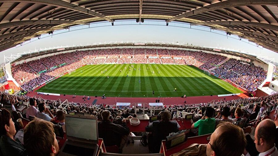 Britannia Stadium - Doluluk Oranı: %98.10
Premier Lig ekiplerinden Stoke City'ye ev sahipliği yapan Britannia Stadyumu, Stoke City her sene düşmemeye oynasa da tribünlerdeki doluluk oranı ile her zaman dikkat çekmeyi başarıyor.Stoke City'nin sergilediği yavan futbola rağmen Stoke City taraftarları takımlarını hiçbir zaman yalnız bırakmıyor.Tam 27.932 kişilik kapasitesi olan Britannia Stadyumu'na her maç ortalama 27.400 kişi taraftar, takımlarını desteklemek için yerlerini alıyor.