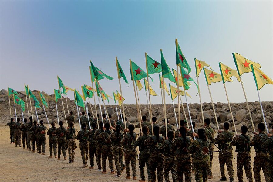 SDG adı altında görünen kaç silahlı adam var?
Net veriler olmasa da 50 bin militanı var. Kadın erkek toplam. Bunların yüzde 70'i YPG ve YPG (kadın unsurlar). Türkmenler olarak benim liderliğimde 65 kişi vardı. Süryani Askeri Meclisi'nin sadece 50 adamı var. Türkmen Askeri Meclisi'nin sembolik olarak kurulmasını istediler. 150 isim önerdim oysa. “Neden 150 ? 50 yeterli” denildi bana. Araplardan Sanadid Güçleri var Şammar aşiretinden. Şeyh Bender bu gücün başında. Bunlar da PKK tarafından yok sayılıyor. Öte yandan Rakka operasyonlarında ölenlerin yüzde 80'i Araplardan yüzde 20'si Kürtlerden. Arapların sayısının artırıldığını görüyoruz ancak kandırıldılar. Sahte vaatler verildi. YPG’liler SDG'nin parçası görünse de bunu kabul etmiyorlar ve biz bağımsızız diyorlar. SDG, sadece bir isimdir. Yeryüzünde gerçek varlığı yok. Batı ülkelerinden YPG’ye katılanların durumu nedir?Çeşitli ülkelerden gelip YPG'ye katıldılar. Kadınlar da vardı. Bazılarının reklam amaçlı geldiğini gördük. Kanadalı bir kadının ülkesinde manken olduğu ortaya çıkmıştı. İçlerinden geri dönenler DEAŞ'a karşı savaştıklarını anlatıyor ve kendilerini milli kahraman ilan etmeye çalışıyor. Örgüt mensupları ne kadar ücret alıyor? Maaşlar aylık 170-200 dolar arasında. Liderler maaşsız ama kaçakçılık ve rüşvetten kazanıyorlar. Ben Şahin Çilo'dan doğrudan maaş alıyordum. Binlerce dolar alıyordum ve durumum gayet iyiydi. Militanlar ise Suriye lirası alıyor. PKK lider takımı maaşsız ancak tüm talepleri yerine getiriliyor. Zaten yolsuzluklar da ortaya çıktı daha sonra.