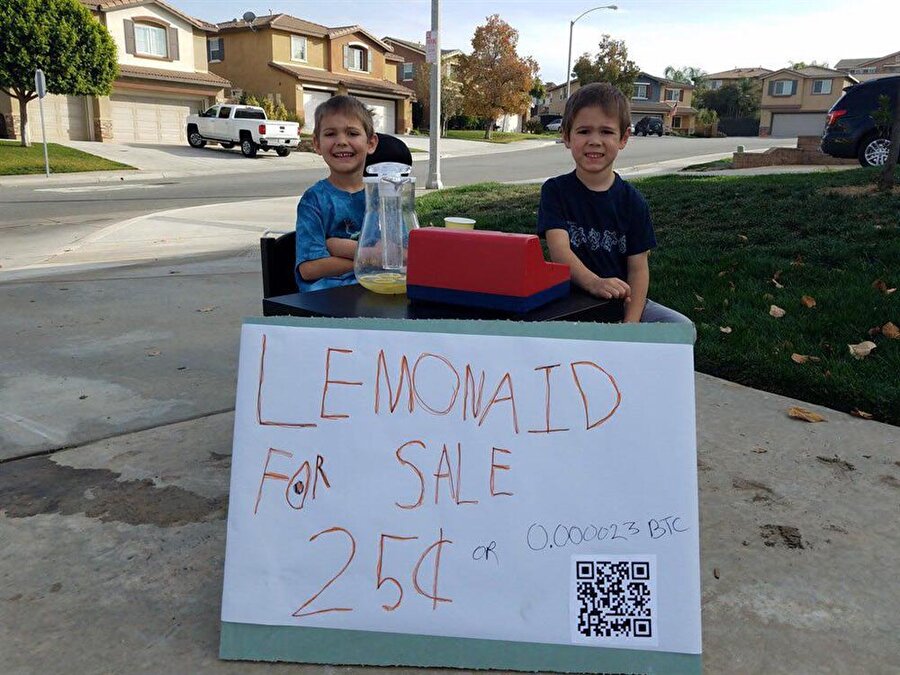 Çocuk girişimciler Bitcoin ile limonata satıyor
Bitcoin, Ethereum ve Ripple gibi sanal para birimleri değer kazanmaya devam ediyor. Evet; yatırımcılar her hafta rekor üstüne rekor kıran bu dijital paralarla önemli oranda kazanç sağlıyor. Elbette yalnızca yatırımla değil; üretimle kazanmak isteyenlerin sayısı da hayli fazla.
Özel bir tabela hazırlayan çocuklar, limonata isteyen kişinin Bitcoin ile ödeme yapabileceğini ifade ederek, QR kodu tarayıp doğrudan hesaba Bitcoin gönderilebileceğini ifade ediyor. Bir bardak limonatanın fiyatı ise 0.000023 BTC. Bu da yaklaşık olarak 1 TL'ye geliyor.