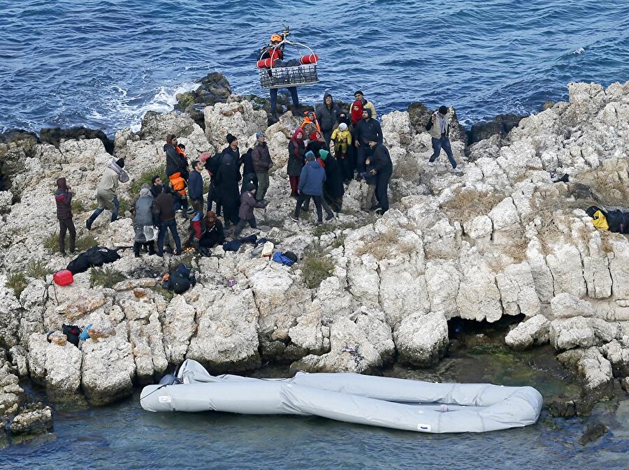 Bölgeye hareket eden sahil güvenlik botları ve helikopteri, kayalıklarda bir lastik bot ile 51 göçmen olduğunu tespit etti.