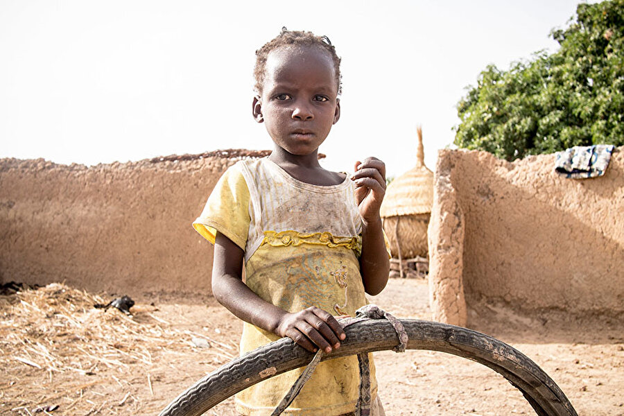 Burkina Faso'da kişi başı 29 dolara geçinilen evde, bir çocuğun en sevdiği oyuncak eski bisiklet tekerleği
