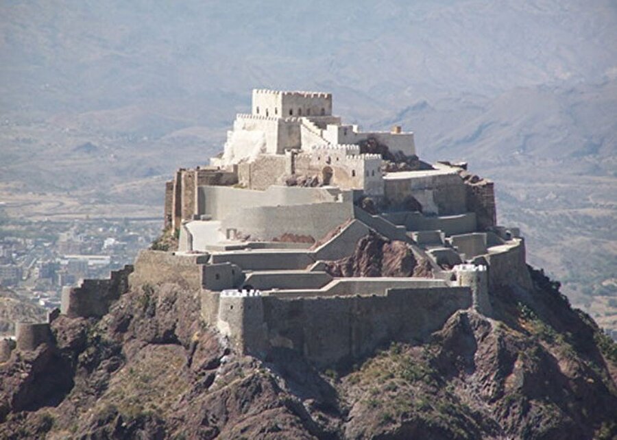 2- Taiz’in Kahire Kalesi
Yemen’deki iç savaş sırasında Taiz şehrindeki tarihi Kahire Kalesi de zarar gördü. 1000 yıldır Taiz semalarını süsleyen 120 metre yükseklikte inşa edilen kale, 2015 yılının Mayıs ayında bombalandı. Sabr Dağı’na inşa edilen kalenin Salihiler döneminde tamamlandığı biliniyor. Osmanlı’dan önce hapishane olarak kullanılmış bu muhkem yapının 4 ana kapısı bulunmakta. Bir zamanlar ulaşılması, ele geçirilmesi imkânsız olan bu kartal yuvası bile modern savaşların yıkıcılığı karşısında aciz ve savunmasız.