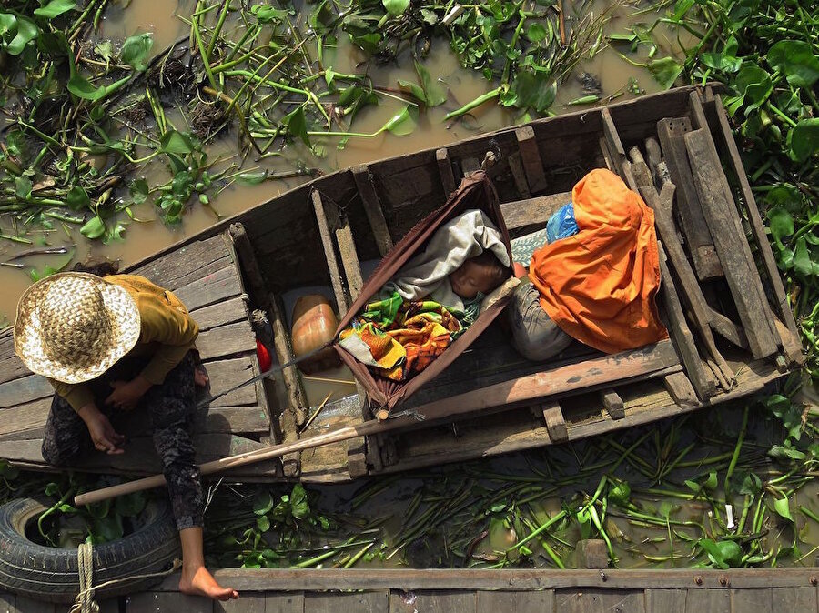​Kamboçya'daki Tonle Sap'ta kayığın içinde bir bebek uyurken
