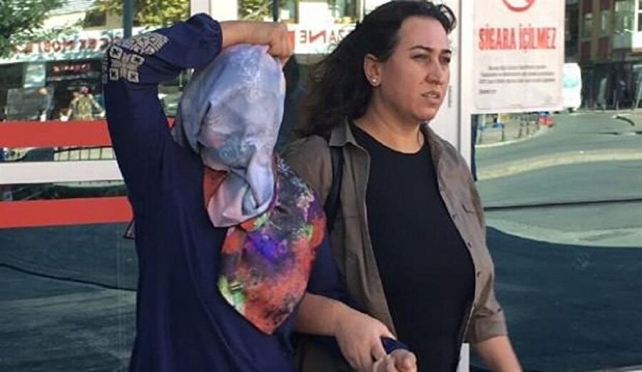 Tartıştığı komşusuna kezzap atan kadın ifade vermeye götürülürken yüzünü gizledi.