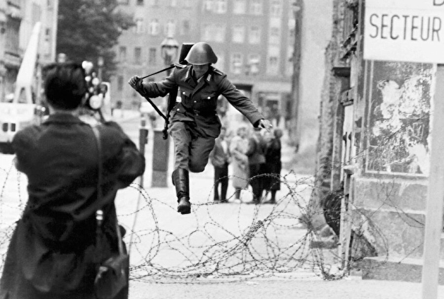 112 kilometrelik 'utanç duvarı'
Böylelikle Berlin'in ortasından yaklaşık 44 kilometre, çevresinde ise 112,7 kilometre uzunluğunda duvar örülmüş oldu. Duvarın yapımı sırasında sınır bölgesinde bulunan bazı evlerden insanlar pencerelerden atlayarak kentin batı kısmına geçtiler.