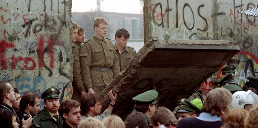 Güvenlik güçlendirildi
Daha sonraki yıllarda duvarın etrafında güvenlik önlemleri artırılarak gözetim kuleleri, ölüm şeridi ve iç duvar gibi başka unsurlar da eklenerek genişletildi. Doğu Berlin ile Batı Berlin arasında 8 sınır geçiş noktası kuruldu. En tanınan sınır geçiş noktası ünlü "Friedrichstrasse" üzerinde bulunan "Checkpoint Charlie" olarak kabul ediliyor.