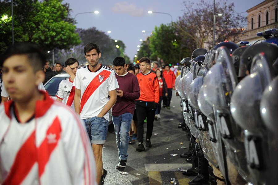 River Plate taraftarları polis koridorunda yürüyor.
