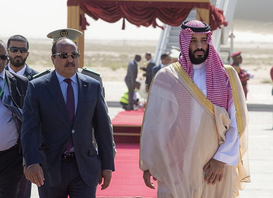 Suudi Arabistan, Amerika İlişkileri
ABD-Suudi ilişkisi, 2019’daki en belirsiz ortaklık olabilirSuudi Arabistan ile ABD ilişkilerinin, Cemal Kaşıkçı suikastının ardından nasıl bir seyir alacağı merakla beklenirken, ABD Başkanı Donald Trump'ın son açıklamaları, stratejik çıkarların önceleneceği tezinin ağır basmasına neden oldu. Daha önce pek çok kez Suudi Arabistan'la ABD arasındaki silah anlaşmalarının tehlikeye atılmasının söz konusu olmadığını söyleyen ABD Başkanı Donald Trump, Beyaz Saray'da gazetecilere yaptığı açıklamada, "100 milyarlarca (silah anlaşmaları) dolardan vazgeçmeyeceğiz. Eğer vazgeçersek petrol fiyatları tavan yapacak." demiş ve Suudi Arabistan'a askeri malzeme satılmaması durumunda Riyad yönetiminin ihtiyacını Rusya ve Çin'den karşılayabileceğini dile getirmişti.
Trump, Riyad yönetimine çok ağır ve muazzam yaptırımlar getirdiğini düşünüyor. (Kaşıkçı suikastıyla ilgili olarak 17 Suudi yetkiliye getirilen yaptırımlar) aynı zamanda da, Yemen'de İran'ın müttefiki olan Husilerle mücadelede ve İran'ın bölgedeki nüfuzunu bertaraf etmede pek çok açıdan iyi iş çıkaran "müttefikine" bağlılığını yineliyor. Veliaht Prens Muhammed bin Selman'ı doğrudan hedef almadan pek çok defa Suudi Arabistan'ı eleştiren Trump, "Kaşıkçı'nın ikna ya da güç kullanma yoluyla ülkeye getirilmesiyle görevli gruba öldürme emrini vermediği" ihtimaline açık kapı bırakıyor.