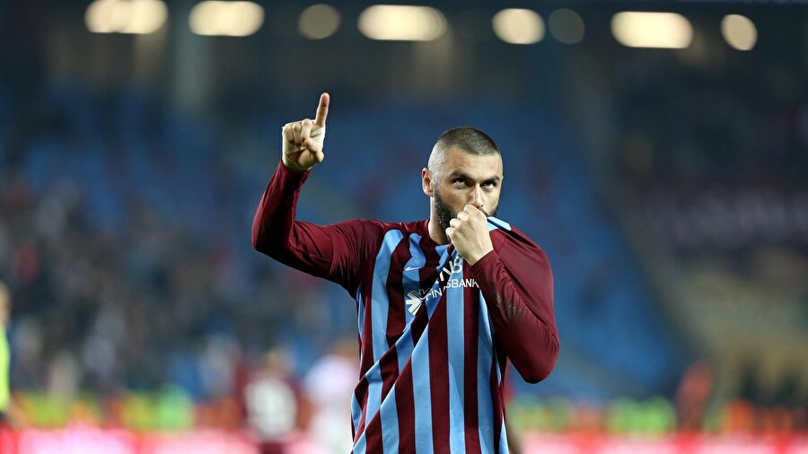 Burak Yılmaz attığı golün ardından bordo mavili armayı öperek taraftarları selamlıyor.