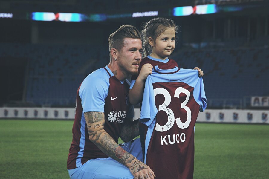 Kucka minik bir Trabzonspor taraftarıyla fotoğraf çektiriyor.