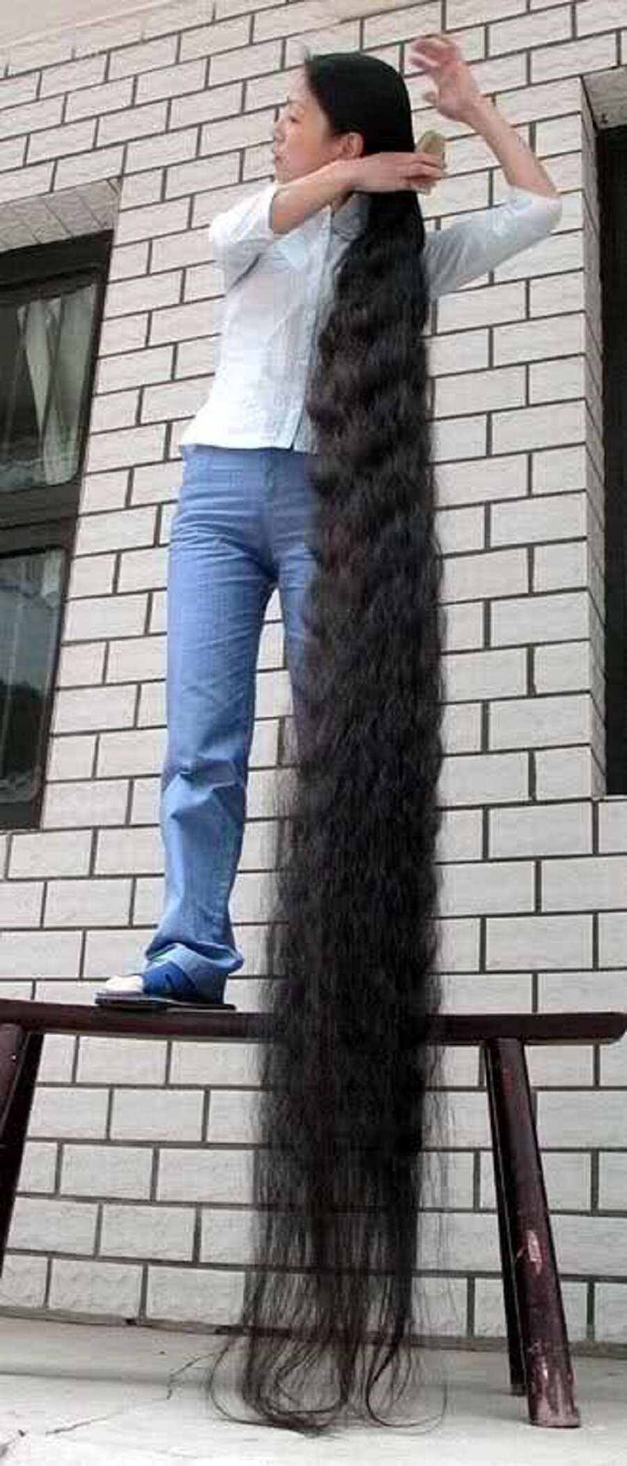 13 yaşından itibaren uzattığı 5.62 m saçıyla dünyanın en uzun saçlı kadını Xie Quiping
