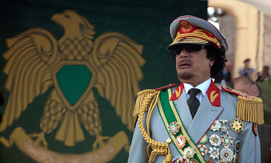 Kaddafi'nin ortağıydı, düşmanı oldu
1943'te Ecdebiye kentinde doğan Hafter, yıkılmadan önce Sovyetler Birliği'nde askeri eğitim gördü. Daha sonra Komutan Kaddafi'nin liderliğindeki orduya katıldı. 1969'da Kaddafi'nin Kral İdris'i devirmesine yardım etti. O günden sonra Kaddafi'nin en güvendiği isim oldu. Kaddafi başa geçtikten kısa süre sonra onu Genelkurmay Başkanlığı'na atadı. Kaddafi'nin Hafter'i oğlu gibi gördüğü söyleniyordu. Kaddafi, Albay rütbesi verdiği Hafter'i 1986'da Çad ile çatışan güçlerin başına getirdi. Hafter'in düşüşü de böylece başladı. Fransa'nın desteklediği Çad güçleri bundan bir yıl sonra Libya'yı yenilgiye uğratarak, Hafter ve 300 askerini esir aldı. Daha önce imzaladığı anlaşma uyarınca Kaddafi askerlerini geri çekti, Hafter'e sırtını döndü.