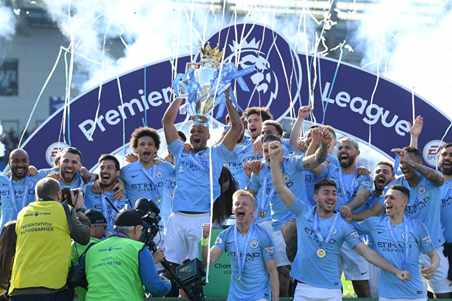 Manchester City'li futbolcular şampiyonluk kupasını seremonide havaya kaldırırken.