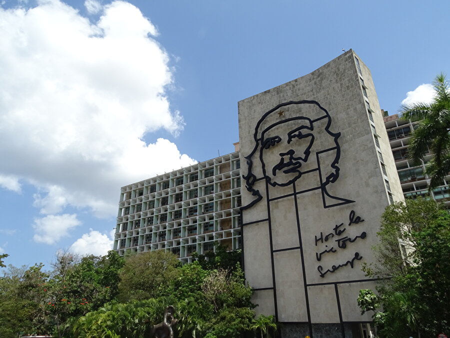 Duvarlarda "devrim" izleri

                                    "Küba Devrimi" olarak bilinen sürecin izlerini hem Havana hem de ülkenin diğer kentlerinde sık sık görmek mümkün. Che Guevera ve Fidel Castro'nun sözleri ve çizilen resimleri, evlerle birçok binanın duvarlarında hemen dikkatinizi çekiyor. 

ABD'nin tüm kısıtlamalarına rağmen çoğunlukla kendi imkanlarıyla ekonomisini ayakta tutmaya çalışan Castro'nun ülkesi, ana gelir kaynaklarından biri olan turizmde gelişmeyi hedefliyor.Bu yıl 39'uncusu düzenlenen Uluslararası Küba Turizm Fuarı (FITCUBA 2019) da bu hedefin ortaya konulduğu arenaya dönüştü. Fuarda, ülkenin doğal, tarihi ve kültürel güzelliklerini anlatan geziler ve konferanslar düzenlenirken, pek çok yabancı konuğun ağırlanması dikkati çekti.


Organizasyon için San Carlos de la Cabana Kalesi'nin seçilmesi de ülkenin farklı özelliklerini gösterme gayretinin bir parçası olarak algılandı. Binlerce kişinin akın ettiği fuarda Havana'nın 500 yıllık geçmişine vurgu yapılması, diğer kentlerin renkli ve alternatif yönlerinin ortaya konulması öne çıkan detaylar arasındaydı. 

Havana yakınlarındaki Varadero, ülkenin tatil beldelerinden biri. "Her şey dahil" otelleriyle turistlerin ilgisini çeken beldenin ince kumu, turkuaz mavisi suları burasının cazibesini artıran unsurlar arasında yer alıyor.Küba, son yıllarda özellikle kanser hastalarının umut bağladığı yerler arasında bulunuyor. Havana'nın bazı yerlerindeki büyük hastaneler dikkati çekiyor. Ülke, bu alandaki yetkinliğini, sağlık turizmiyle de taçlandırmanın planlarını yapıyor.
                                