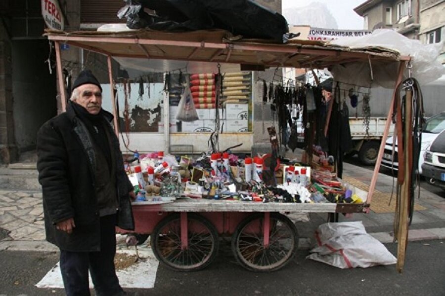 Tezgâhta pek öyle etkileyici bir şey yok. Cebinden koyu renkli cam bir şişe çıkarıyor.