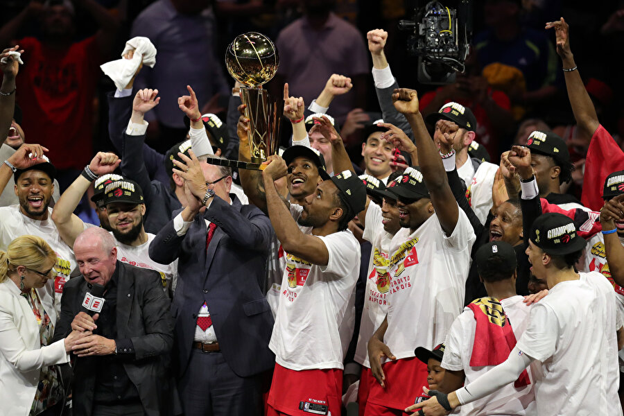 Toronto Raptors kafilesi kupayı kaldırıyor.