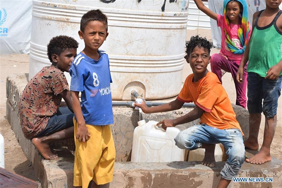 Aden'de bulunan bir kampta içme suyu dolduran çocuklar. Yemen.