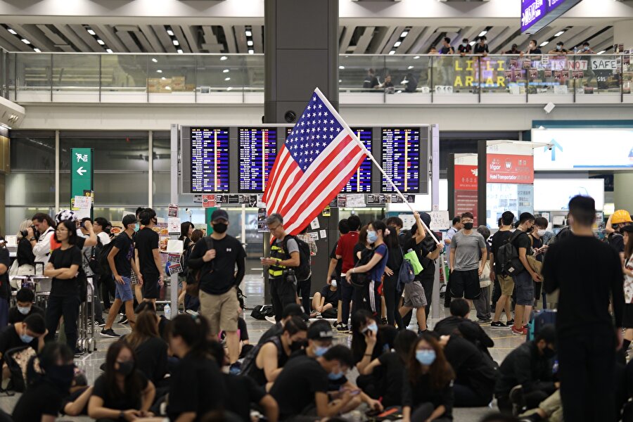 Binlerce Hong Konglu, protestolara polis müdahalesinin sertleşmesine tepki olarak sabah saatlerinde havalimanının ana terminalini, geliş ve gidiş salonlarını işgal etti.