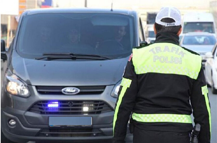 Bir polis, çakar lamba ve abartı egzoz denetimi yaptığı sırada görünüyor.