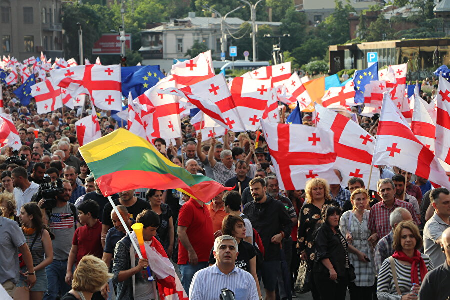 Gürcistan

                                    
                                    Gürcistan'ın başkenti Tiflis'te, 26. Ortodoks Parlamentolararası Genel Asamblesi toplantısına bir Rus milletvekilinin başkanlık etmesine tepki olarak başlayan protesto gösterileri, binlerce kişinin katıldığı "Özgürlük Yürüyüşü" ile sürmüştü. Şota Rustaveli Caddesi'nde bir araya gelen göstericiler, Gürcistan İçişleri Bakanı Giorgi Gakharia'nın istifa etmesi talebiyle Özgürlük Meydanı'na kadar "Özgürlük Yürüyüşü" yapmıştı. Binaya girmeye çalışan göstericilerle polis arasında arbede yaşanmış, emniyet güçleri protestocuları dağıtmak için biber gazı, plastik mermi ve tazyikli su kullanmıştı.Gürcistan hükümeti, göstericilerin seçim sisteminde değişiklik yapılması talebini kabul etmişti. Protestoların devam edeceğinin anlaşılması üzerine Meclis Başkanı İrakli Kobakhidze, 21 Haziran'da istifa ettiğini açıklamış, Azerbaycan'daki resmi temaslarını durdurarak ülkesine dönmüştü.
                                
                                