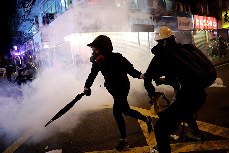 Hong Kong

                                    
                                    Hong Kong yönetimi, "şüphelilerin Çin ana karası, Çin'in Makao Özel İdari Bölgesi ve Tayvan'a iadesini kolaylaştıran" yasa tasarısını 3 Nisan'da parlamentoya sunmuştu. Tasarının, Hong Kong'un özerk yönetim yapısı ve yargı bağımsızlığını zedeleyerek kenti, Çin merkezi yönetiminin güdümüne sokacağını düşünen muhalefet, haziran başında kentte büyük kitlesel protestolar başlatmıştı. Protestoların gün geçtikçe şiddetini artırması üzerine Hong Kong Baş Yöneticisi Carrie Lam, temmuzda tasarının "öldüğünü" açıklamış, gösterilerin sürmesi üzerine 4 Eylül'de tasarının geri çekileceğini duyurmuştu. Tasarı, 23 Ekim'de resmen geri çekilmesine rağmen protestocular, "demokratik reform" talepleriyle eylemlerine devam ediyor.
Göstericiler, protestoların "ayaklanma" olarak adlandırılmasına son verilmesini, polis şiddetinin soruşturulması için bağımsız komisyon kurulmasını, tutuklanan protestoculara af çıkarılmasını ve kentte siyasi reform sürecinin yeniden başlatılmasını talep ediyor.
Şu ana kadar 3 binden fazla kişinin gözaltına alındığı protestolar, Hong Kong'un son 10 yılda ilk defa ekonomik durgunluk yaşamasına yol açtı.
                                
                                