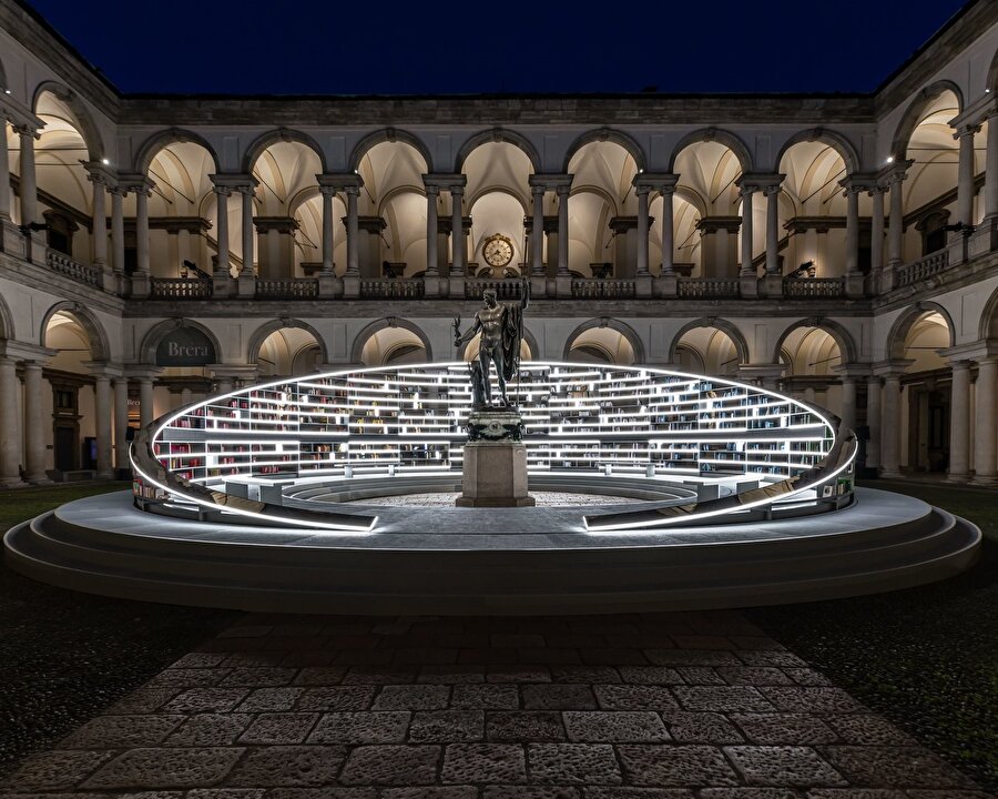 Müzik eşliğinde tarihi bir avluda döner bir kütüphane 