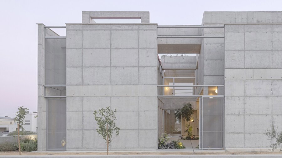Beton kütle olarak tasarlanan konut, peyzajla ilişkisini düşey yarıklarla kuruyor