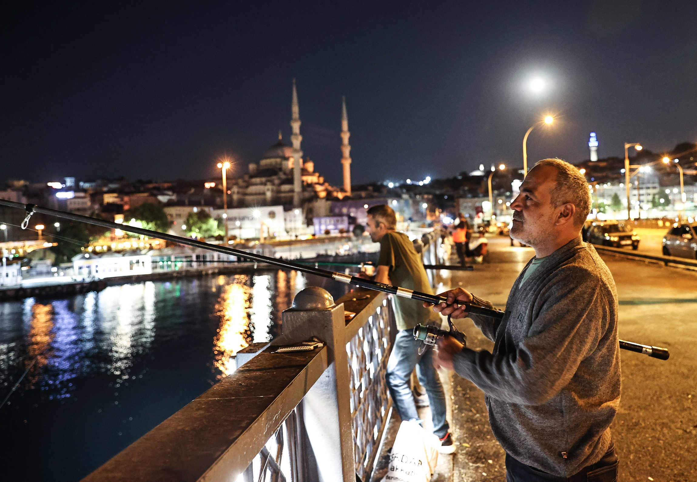 Fishermen catch fish at Galata Bridge in Istanbul