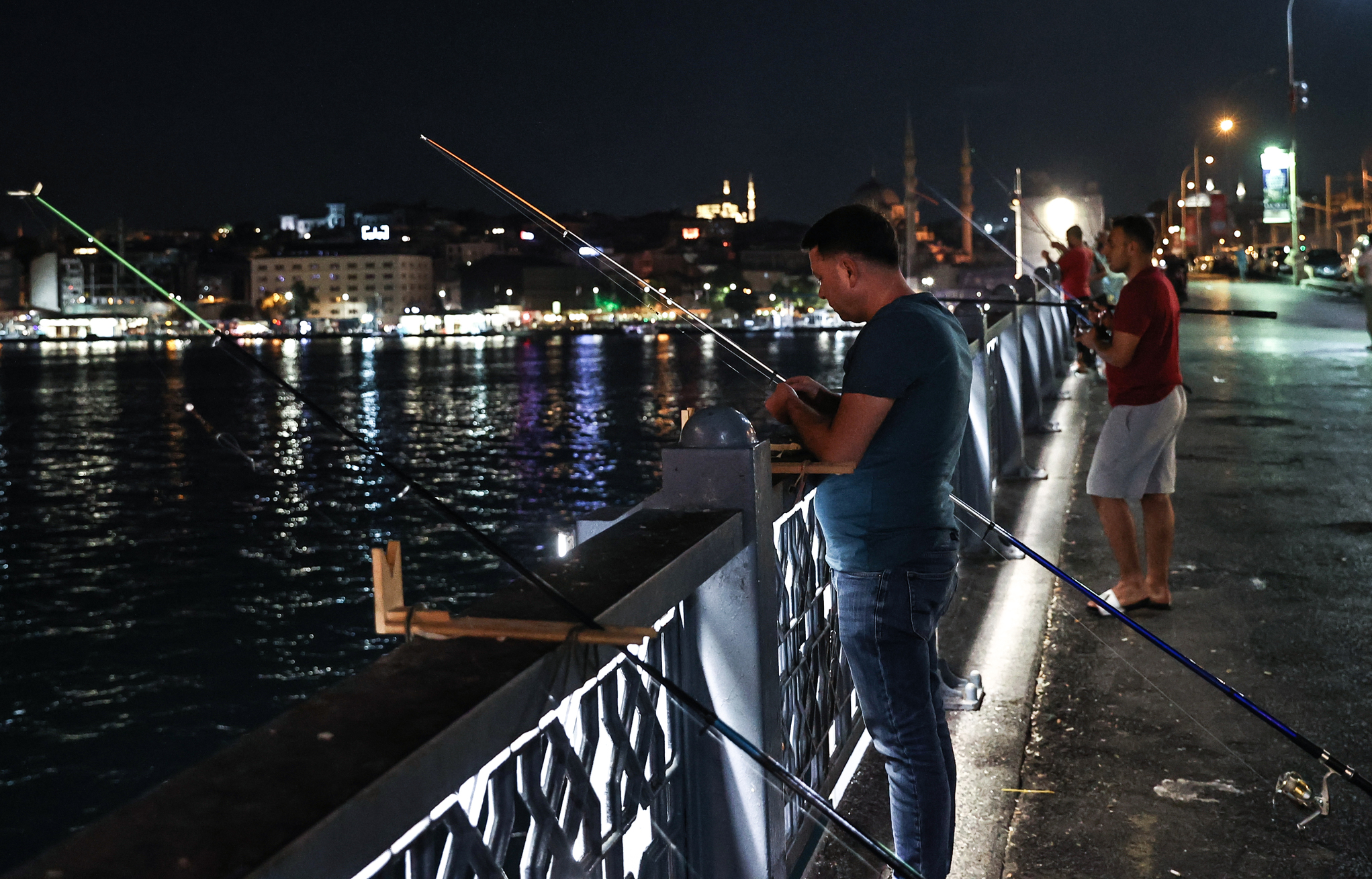 Fishermen catch fish at Galata Bridge in Istanbul
