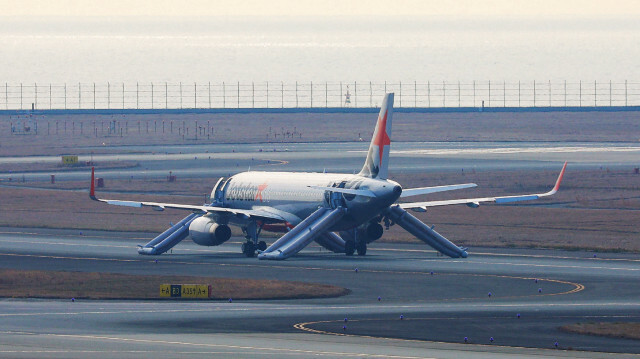 Un avion Jetstar est assis sur la rampe de taxi après avoir effectué un atterrissage d'urgence à la suite d'une alerte à la bombe.  JIJI PRESS. @AFP