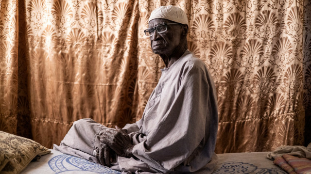Diogo Dieye, 103 ans, ancien tirailleur sénégalais, qui a combattu pour la France pendant la Seconde Guerre mondiale, au Liban et à Libreville, pose pour un portrait sur son lit à Thiès, au Sénégal, le 22 décembre 2022. @ JOHN WESSELS / AFP