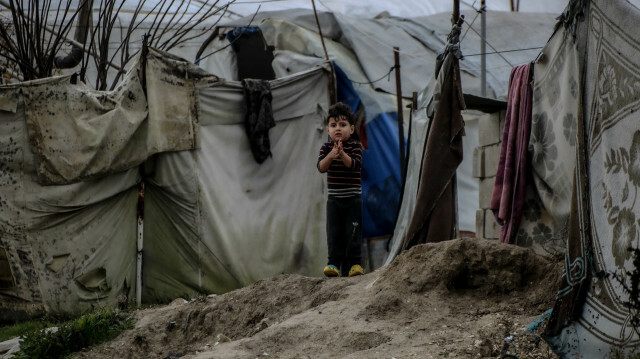 Un enfant est vu devant une tente de fortune au camp de réfugiés d'Ataa, où des civils sont déplacés par les attaques du régime de Bashar Assad alors qu'ils luttent contre les conditions hivernales difficiles à Idleb, en Syrie, le 25 décembre 2022. @ AA