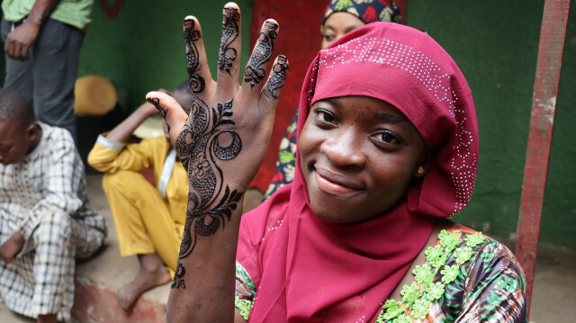 Une jeune femme montre sa main peinte au henné, à Yaoundé, au Cameroun, le 30 décembre 2022. @ AGENCE ANADOLU