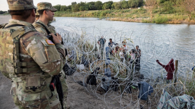 Des membres de la Garde nationale observant des migrants qui tentent de passer à travers les barbelés à Eagle Pass, au Texas, le 24 septembre 2023. Crédit photo: ANDREW CABALLERO-REYNOLDS / AFP