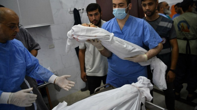 Un médecin porte le corps d'un enfant palestinien tué lors de frappes aériennes israéliennes à  à Gaza le 12 Octobre 2023. Crédit photo: AA