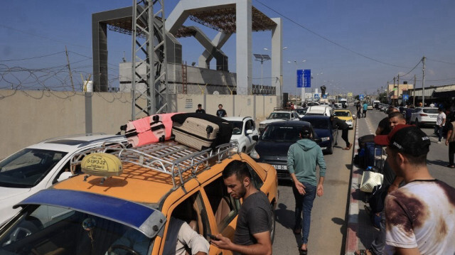 Des Palestiniens arrivent à la porte de Rafah, alors que les attaques israéliennes sur la bande de Gaza se poursuivent le 14 octobre 2023. Crédit photo: SAID KHATIB / AFP