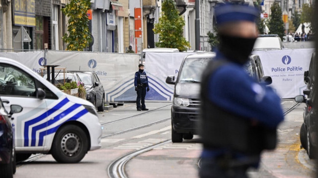 Des policiers montent la garde devant le bâtiment situé dans le quartier de Schaerbeek à Bruxelles, le 17 octobre 2023, où l'auteur présumé de l'attaque à Bruxelles a été abattu lors d'une intervention policière. Crédit photo: JOHN THYS / AFP
